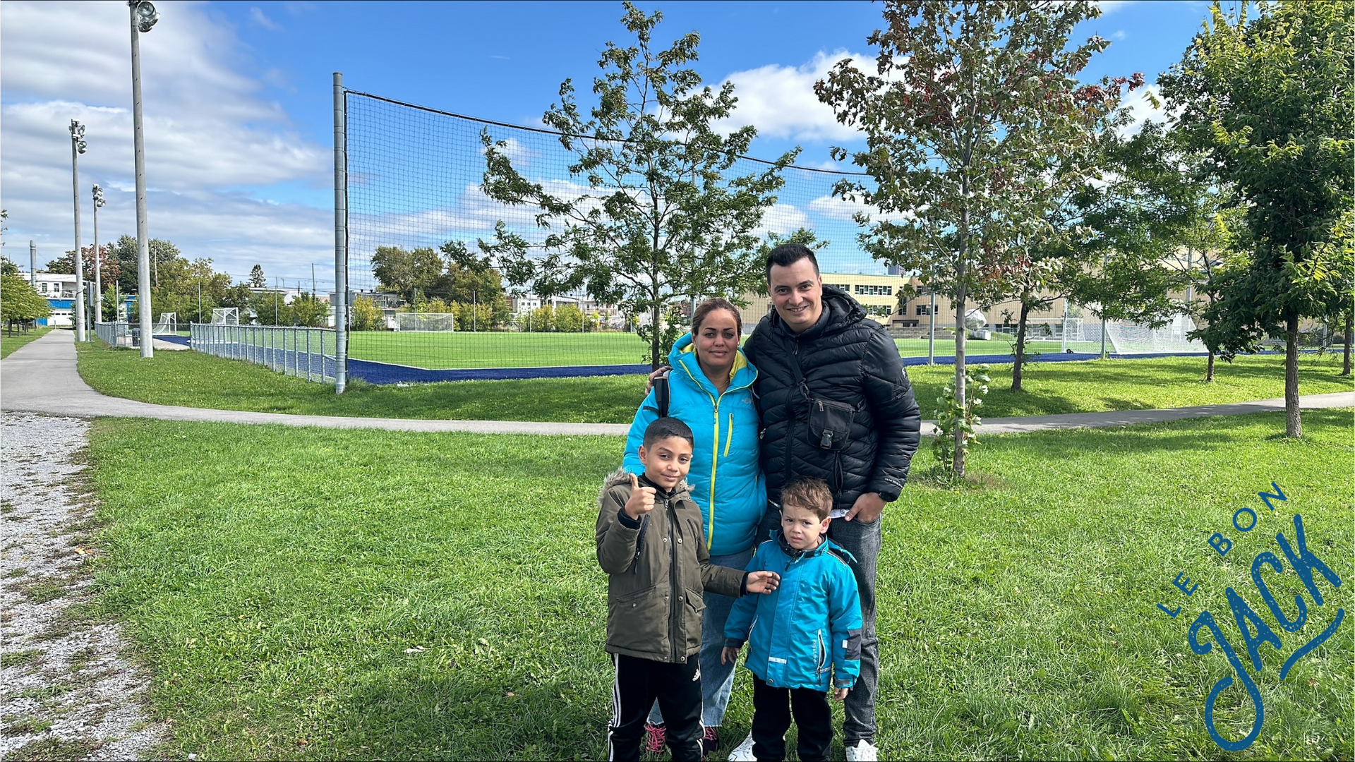 A family is posing for a picture in a park.