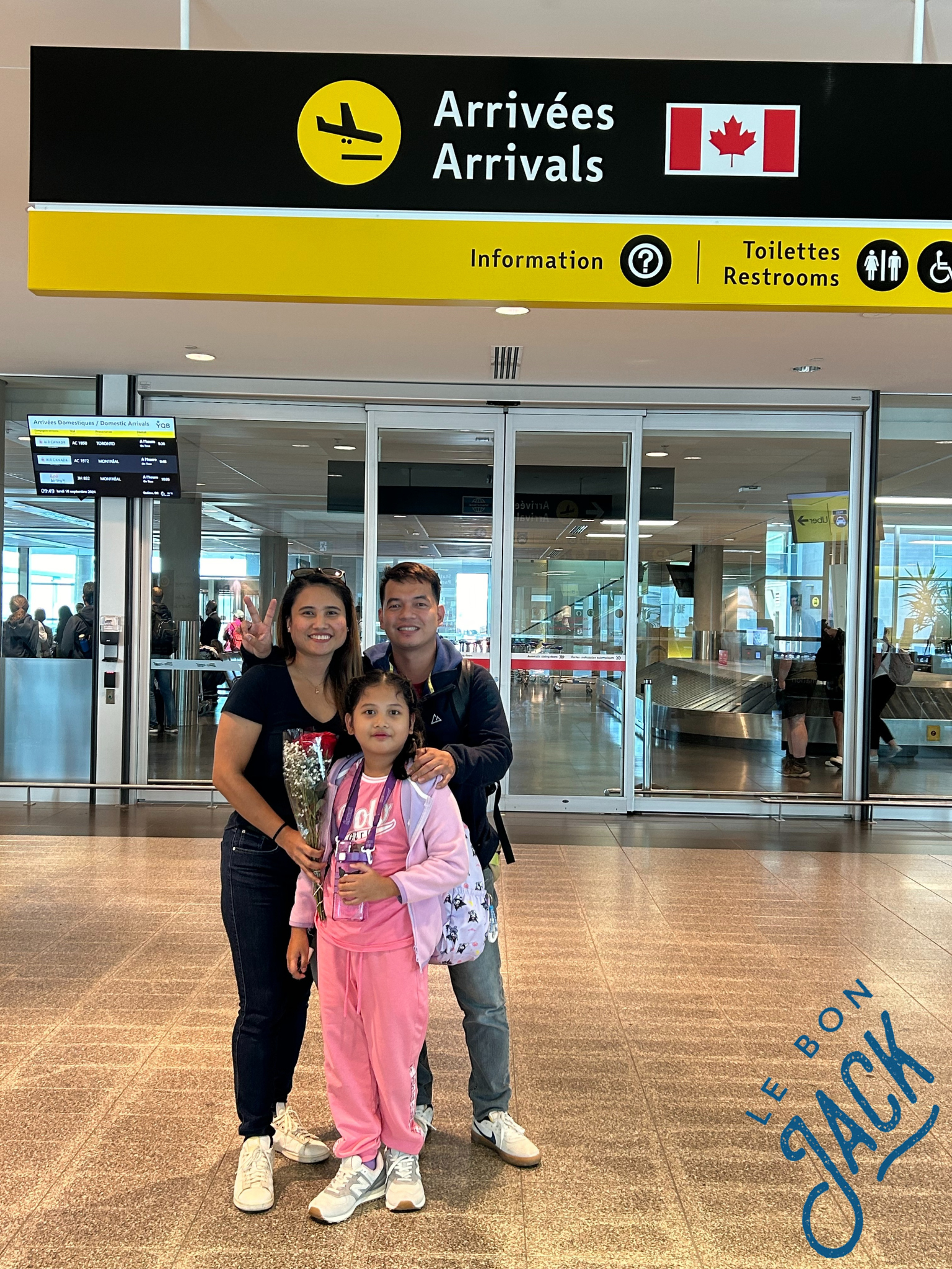 A family standing in front of a sign that says arrivées arrivals