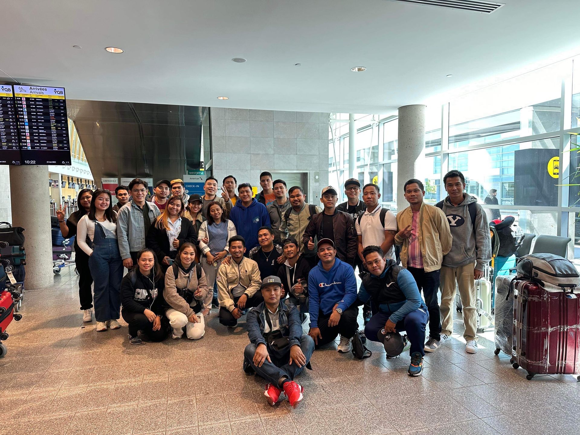 A group of people are posing for a picture in an airport.