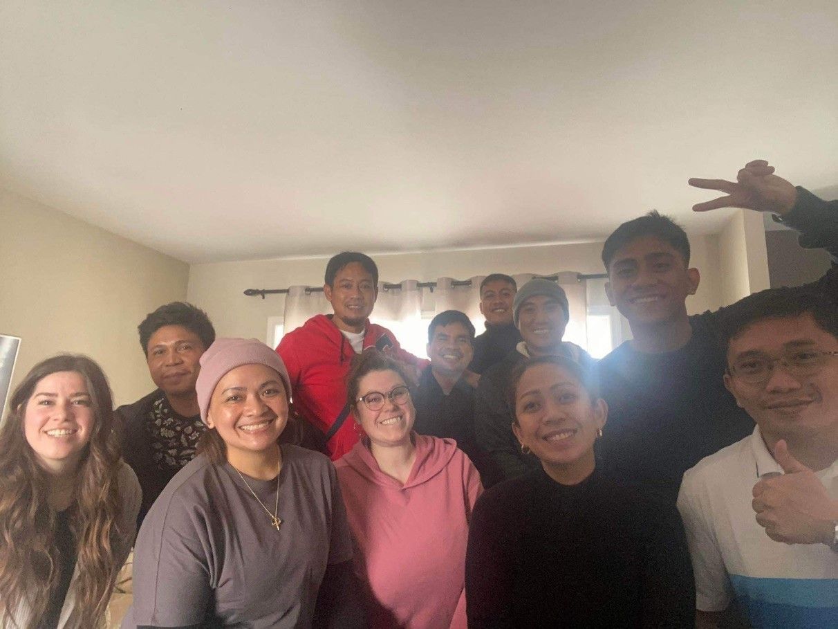 A group of people are posing for a picture in a living room.