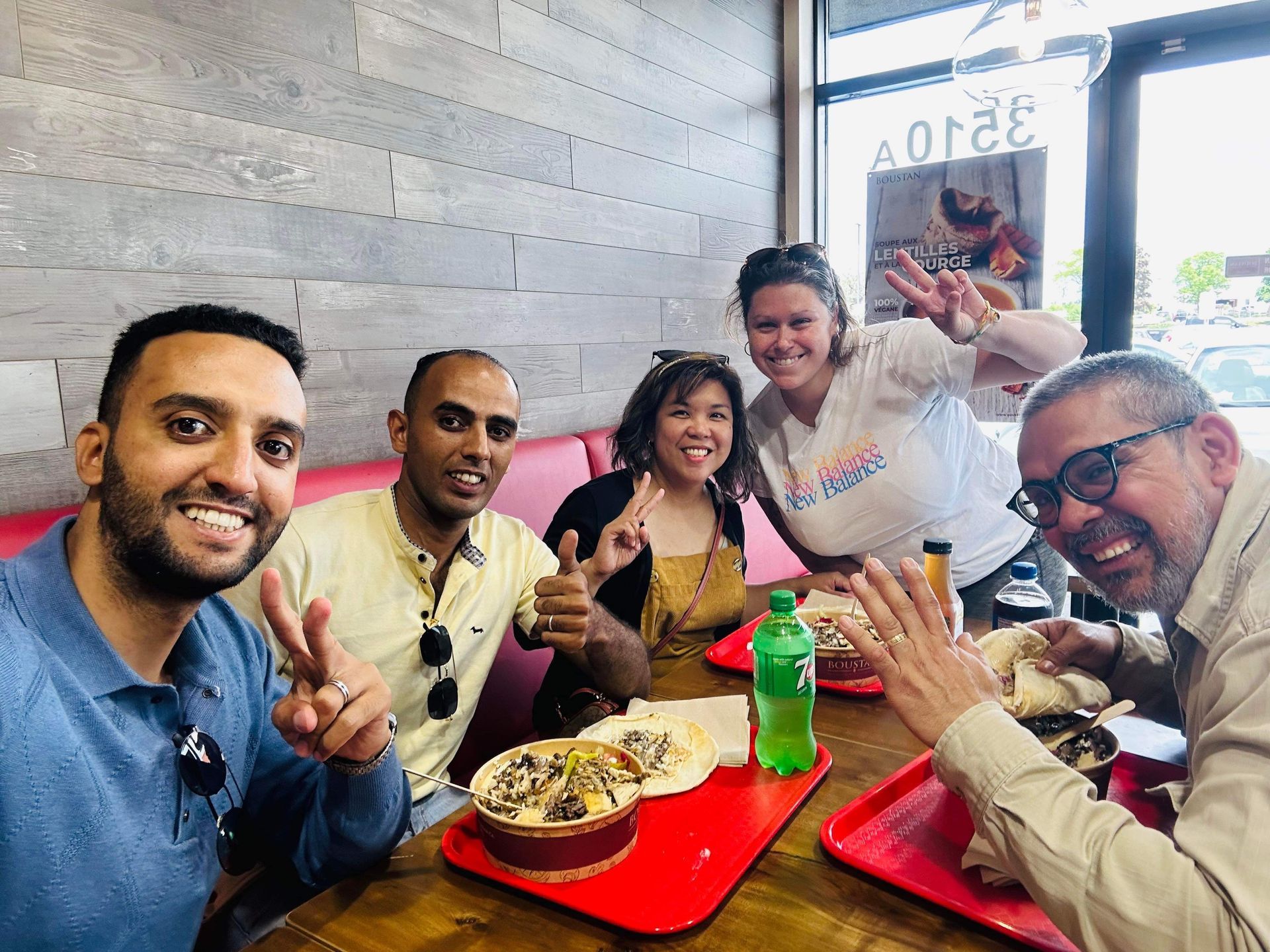 A group of people are sitting at a table in a restaurant eating food.