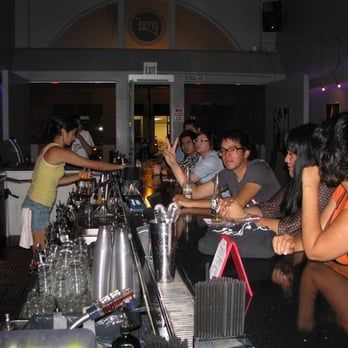 A group of people sitting at a bar with a sign that says exit