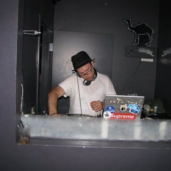 A dj with a supreme sticker on his laptop