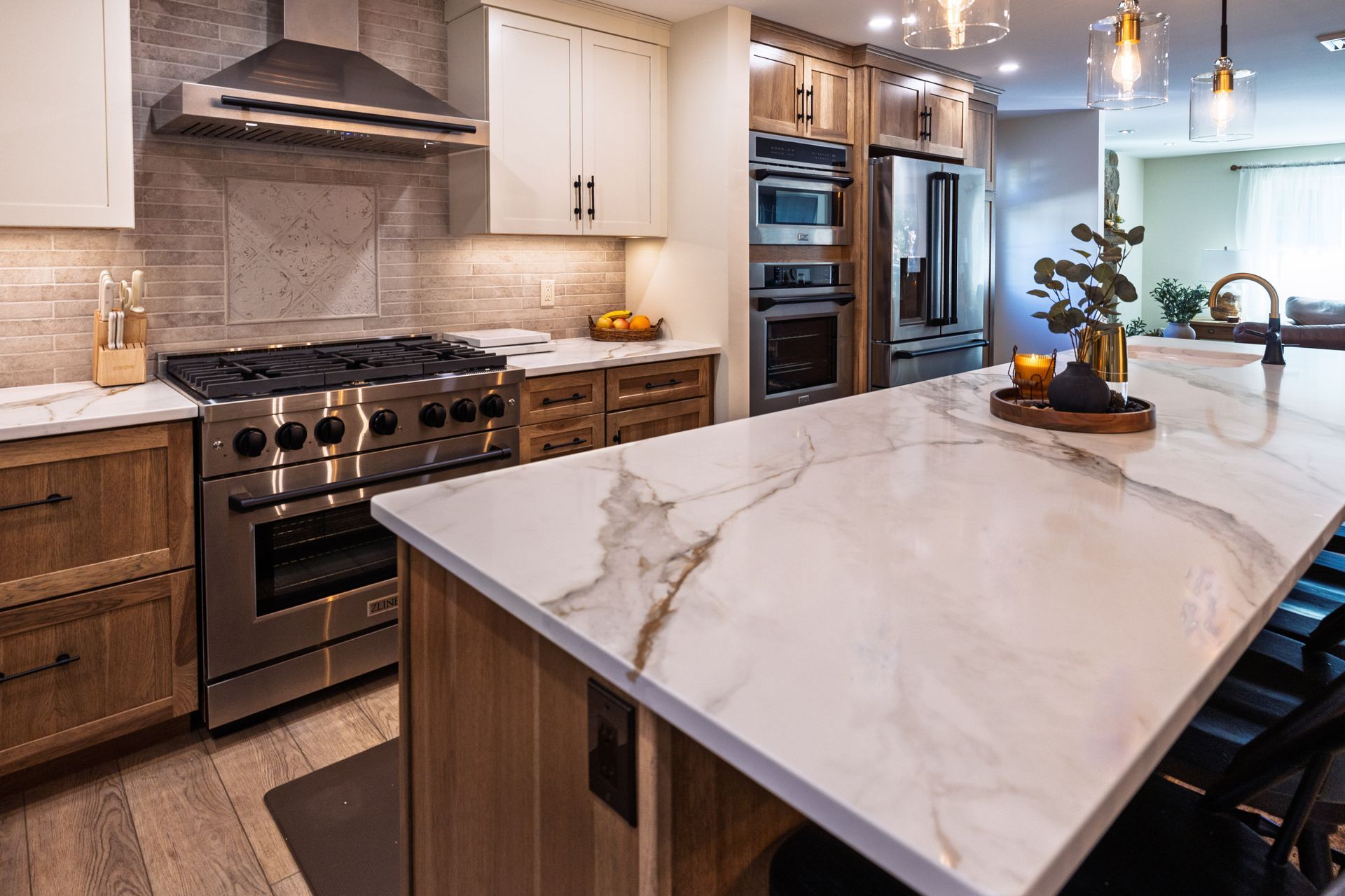Modern kitchen with marble island, stainless steel appliances, and wood cabinets
