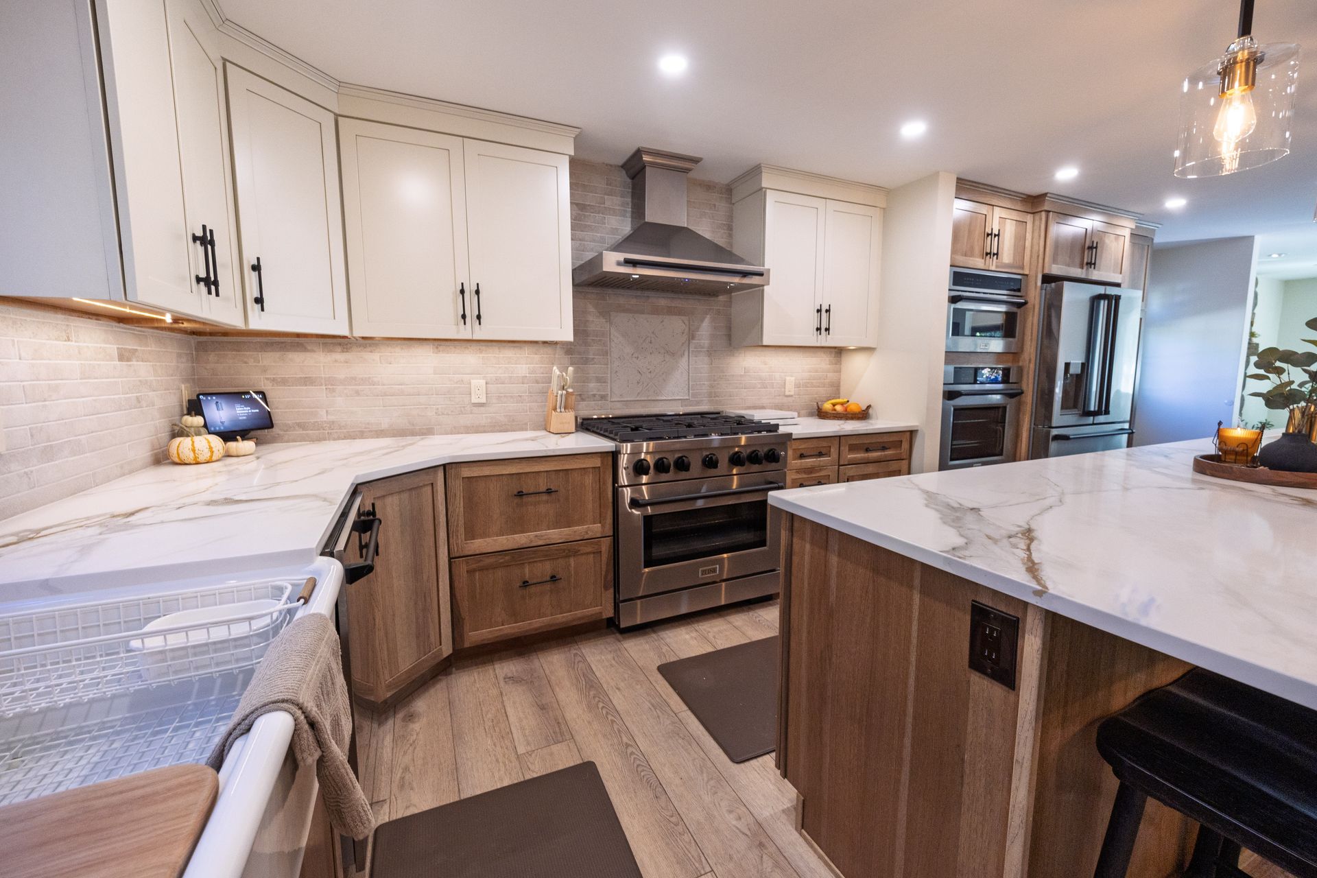 Bright modern kitchen with white cabinets, stainless steel stove, and large marble island
