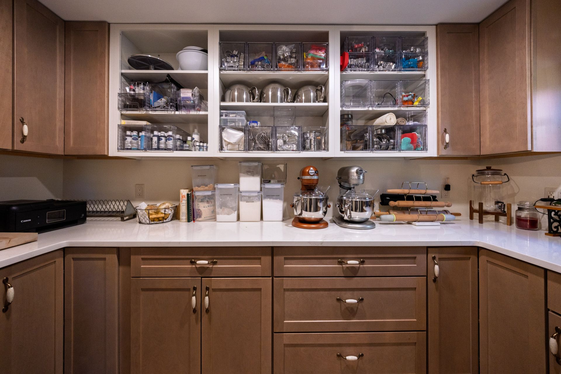 Kitchen pantry with open shelves, glassware, dishes, and countertop appliances in warm wood cabinets
