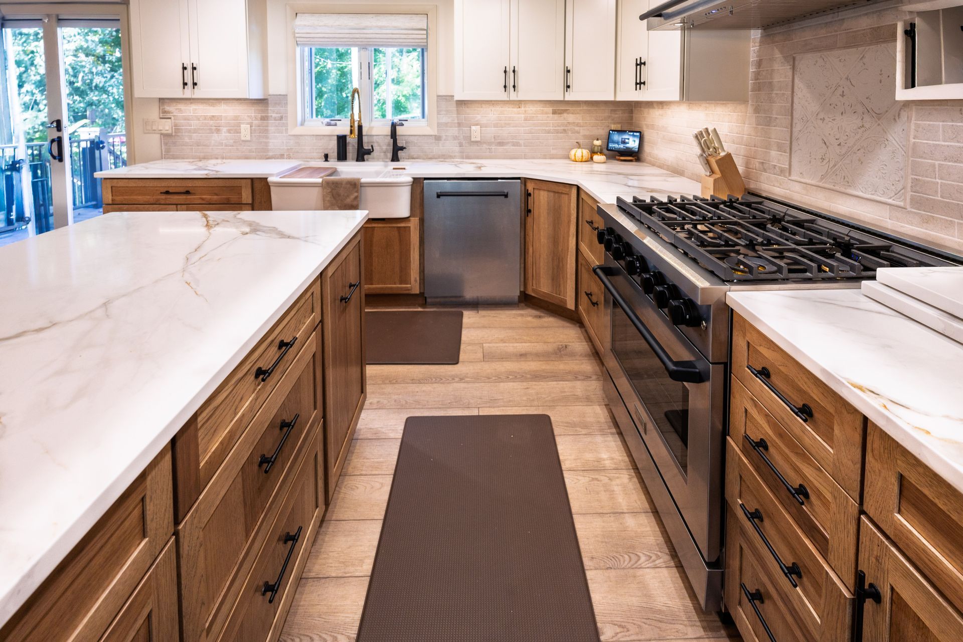 Bright kitchen with white countertops, wood cabinets, stainless dishwasher, and a gas stove.