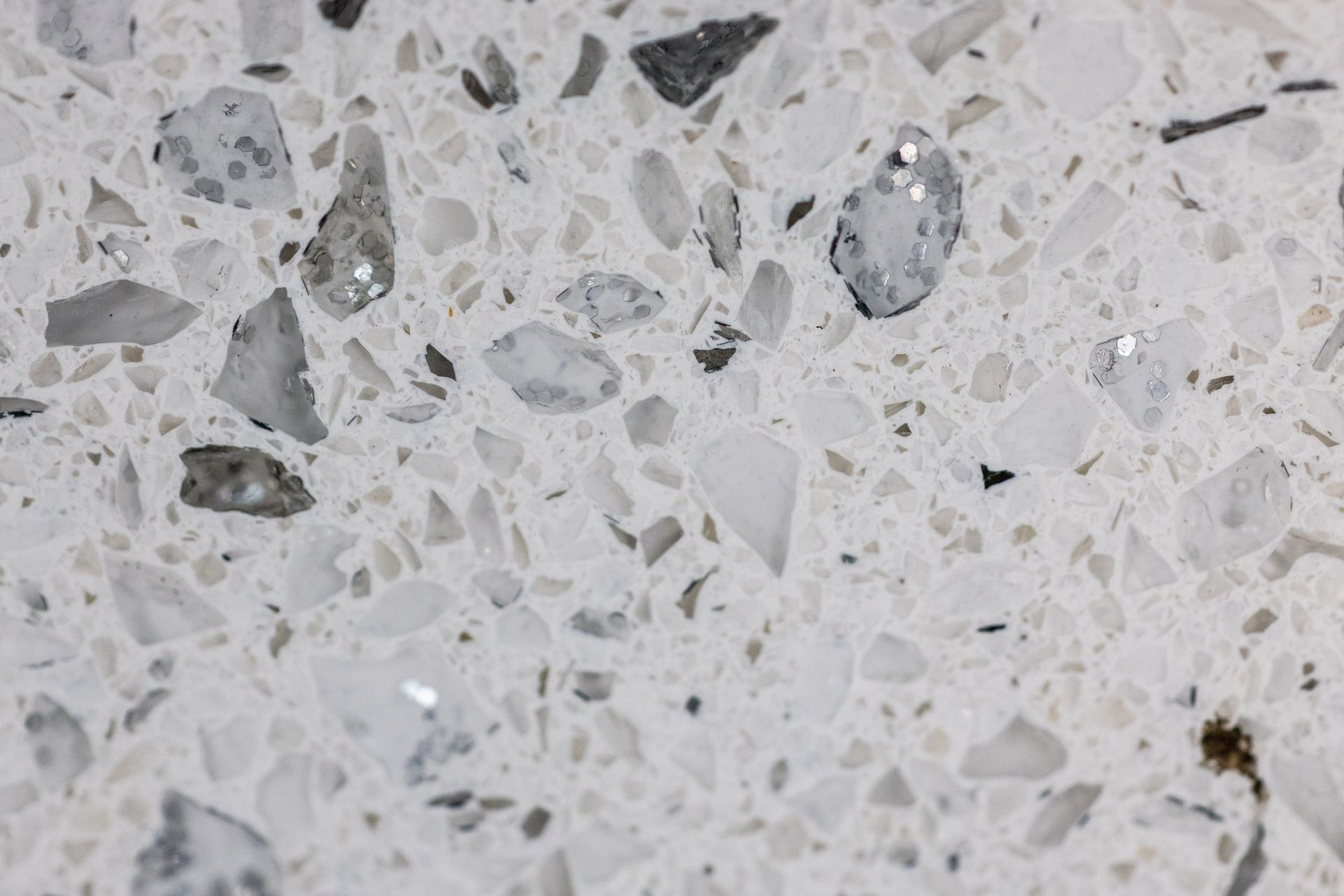 Close-up of light gray terrazzo surface with embedded white and dark stone chips
