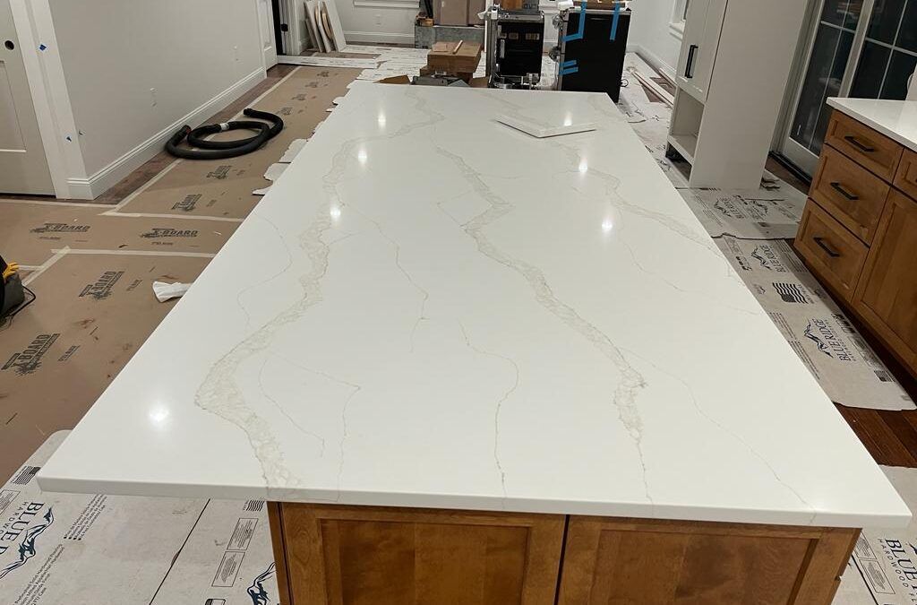 White countertop with subtle gray veining on a wooden kitchen island in a room under renovation