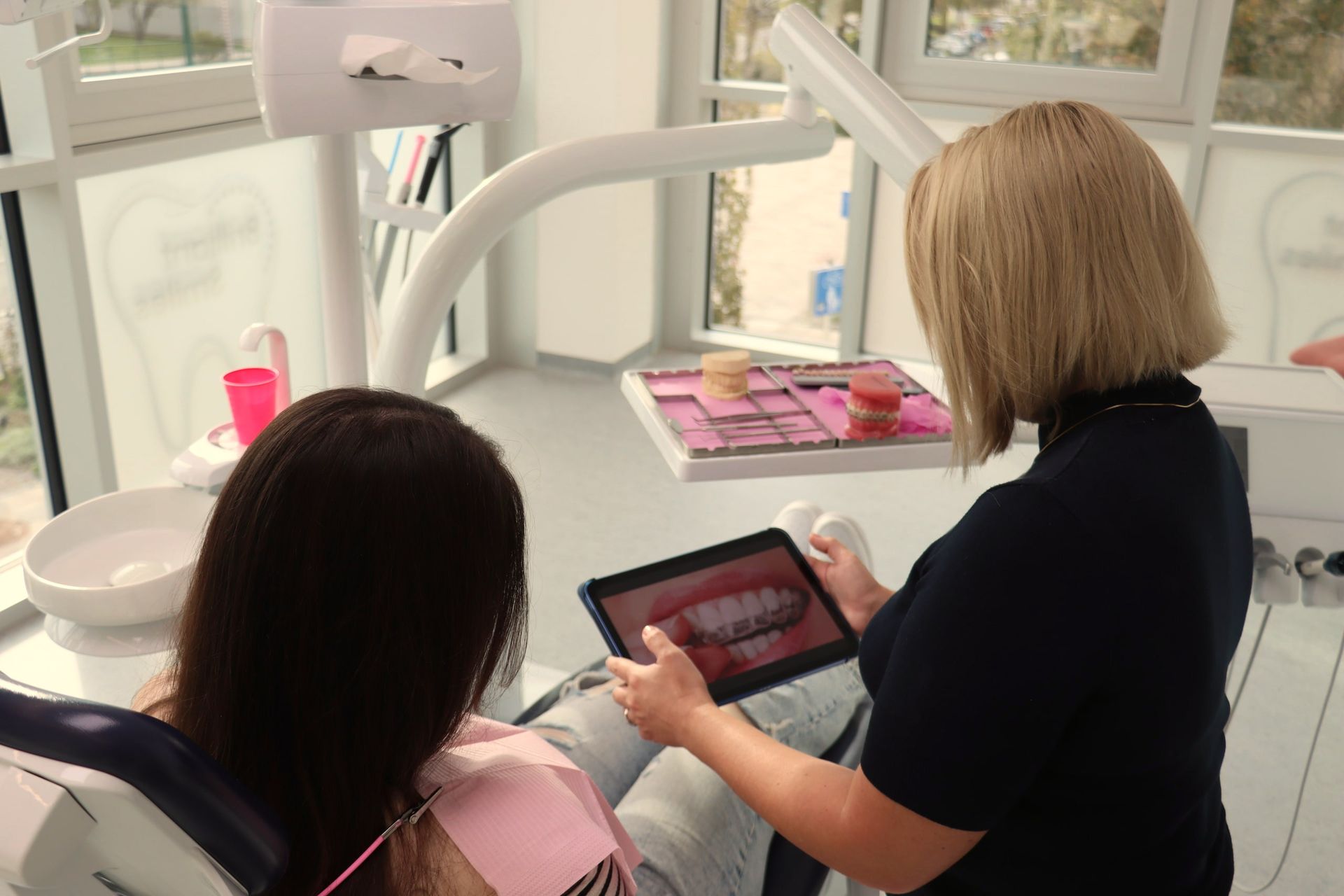 Zahnarzt zeigt Patienten ein Bild der Zähne auf einem Tablet. Zahnarztpraxis.