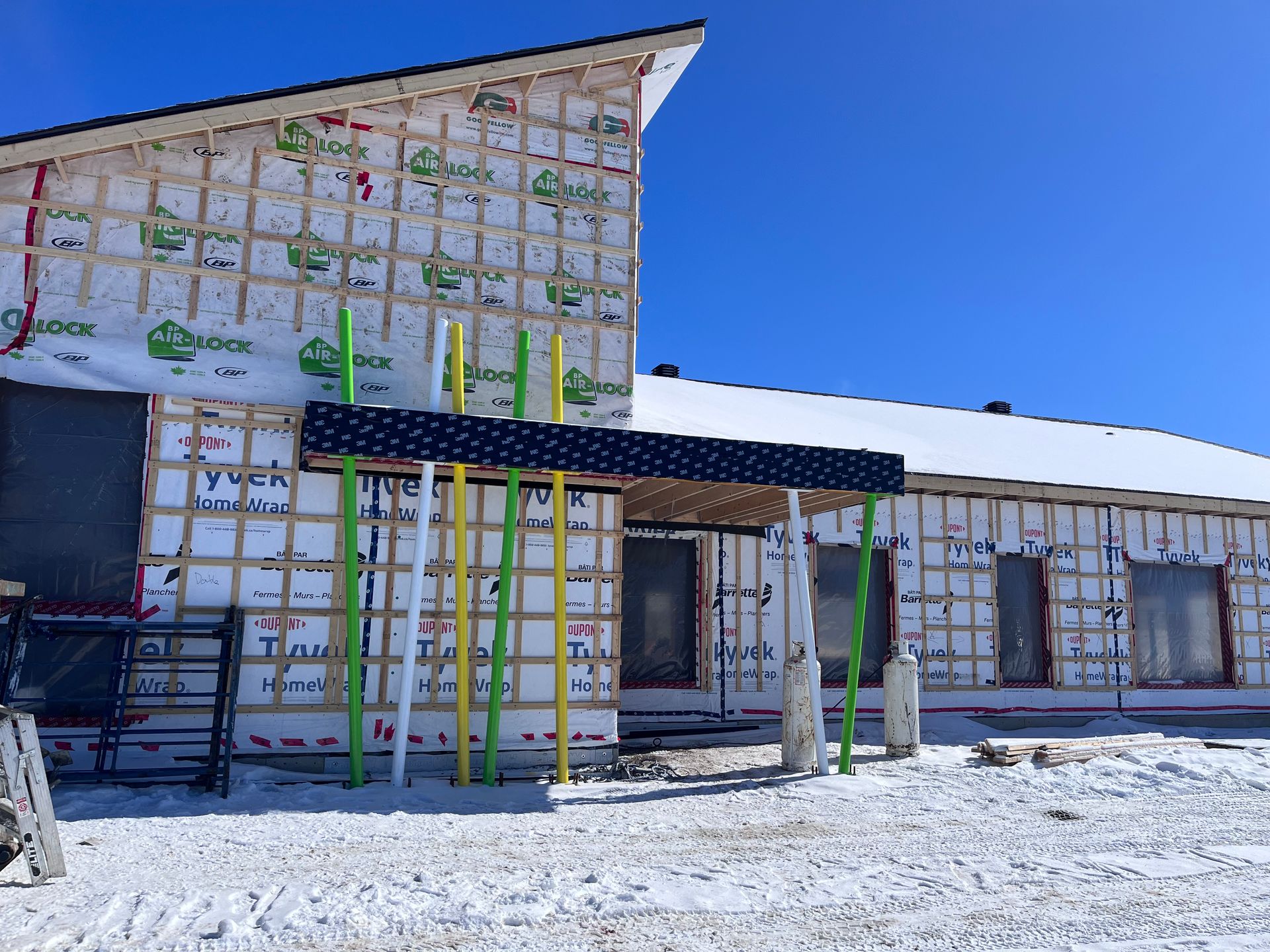 Un bâtiment est en construction dans la neige avec un ciel bleu en arrière-plan.