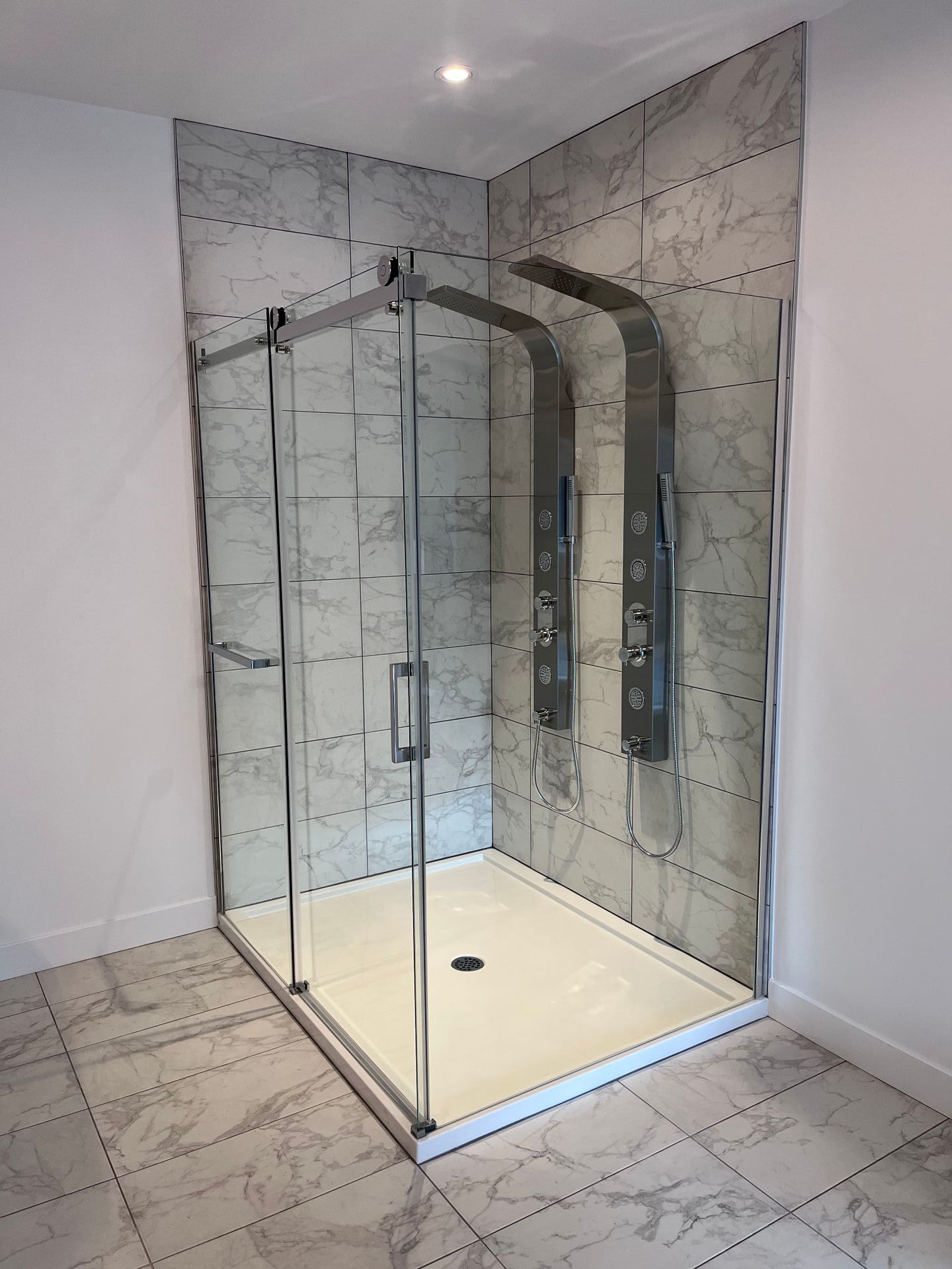 Une salle de bain avec douche à l'italienne et pomme de douche.