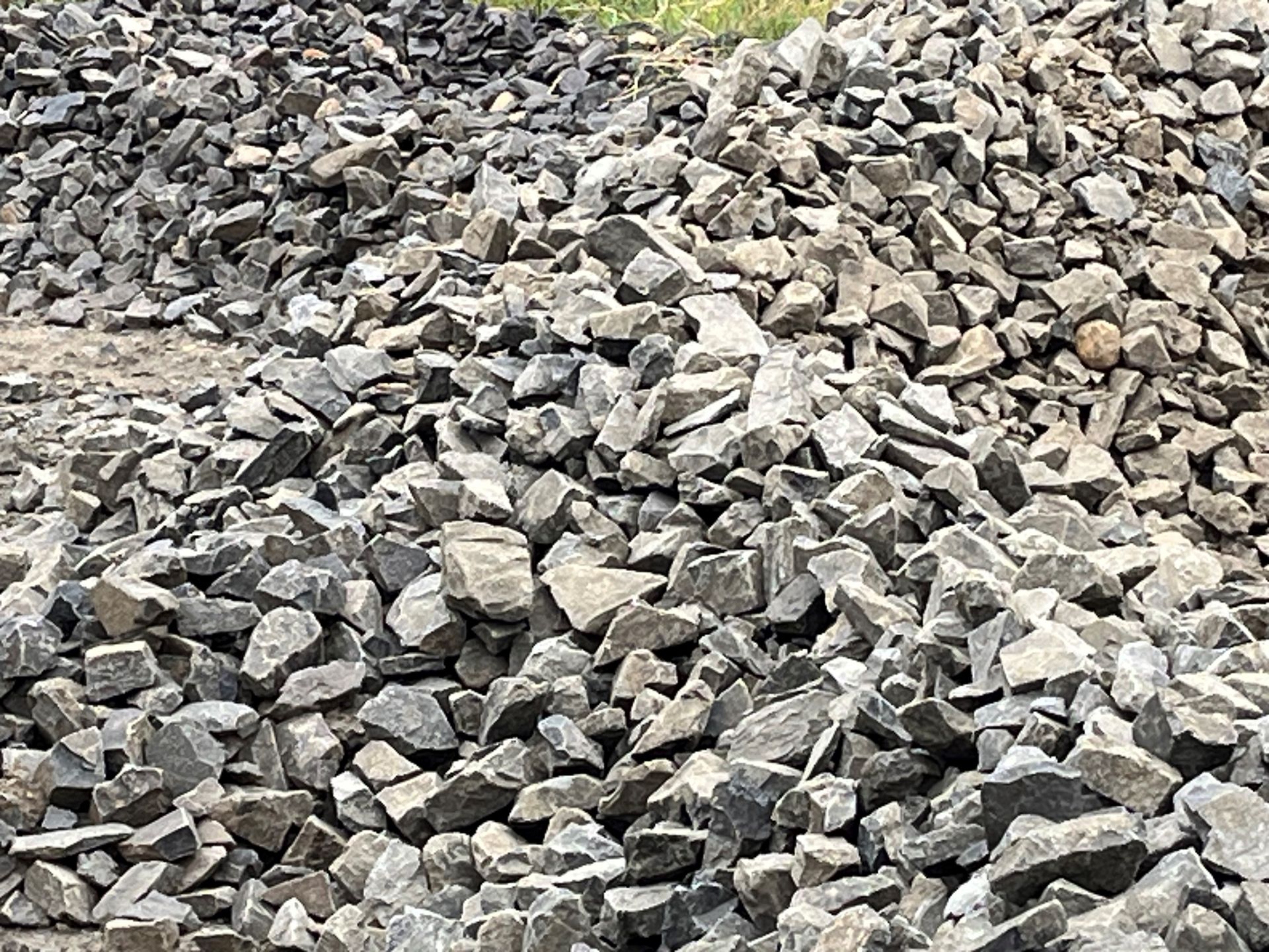 A drainage filled with gravel and a metal grate.