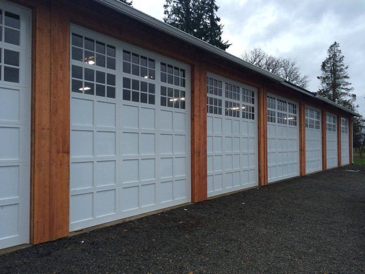 White garage doors with multiple window panes and wood trim.