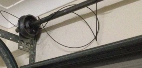 Garage door torsion spring system with cable loop.