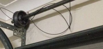 Garage door torsion spring system with cable loop.