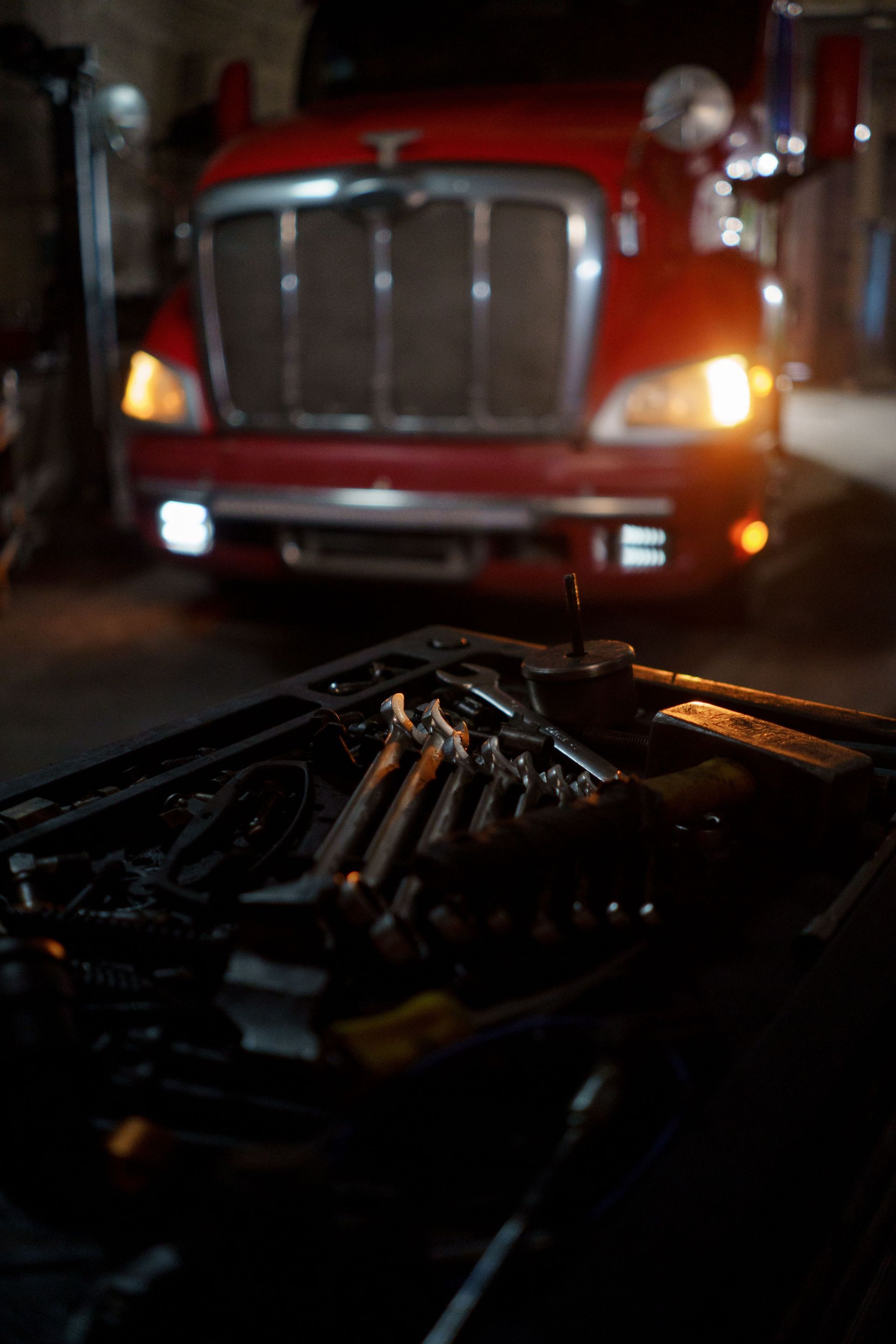 Tools on a car dashboard with a red semi-truck stopped ahead at night