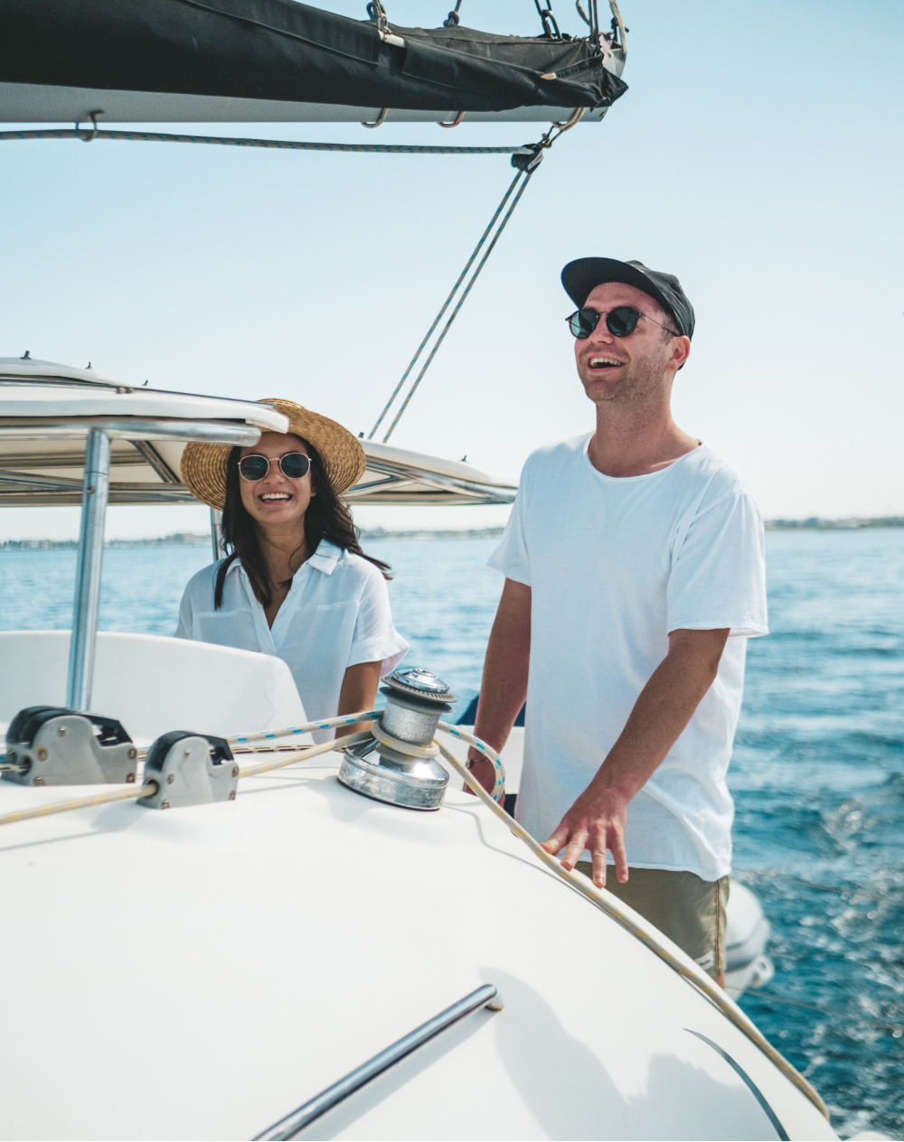 A man and a woman are standing on a boat in the ocean.