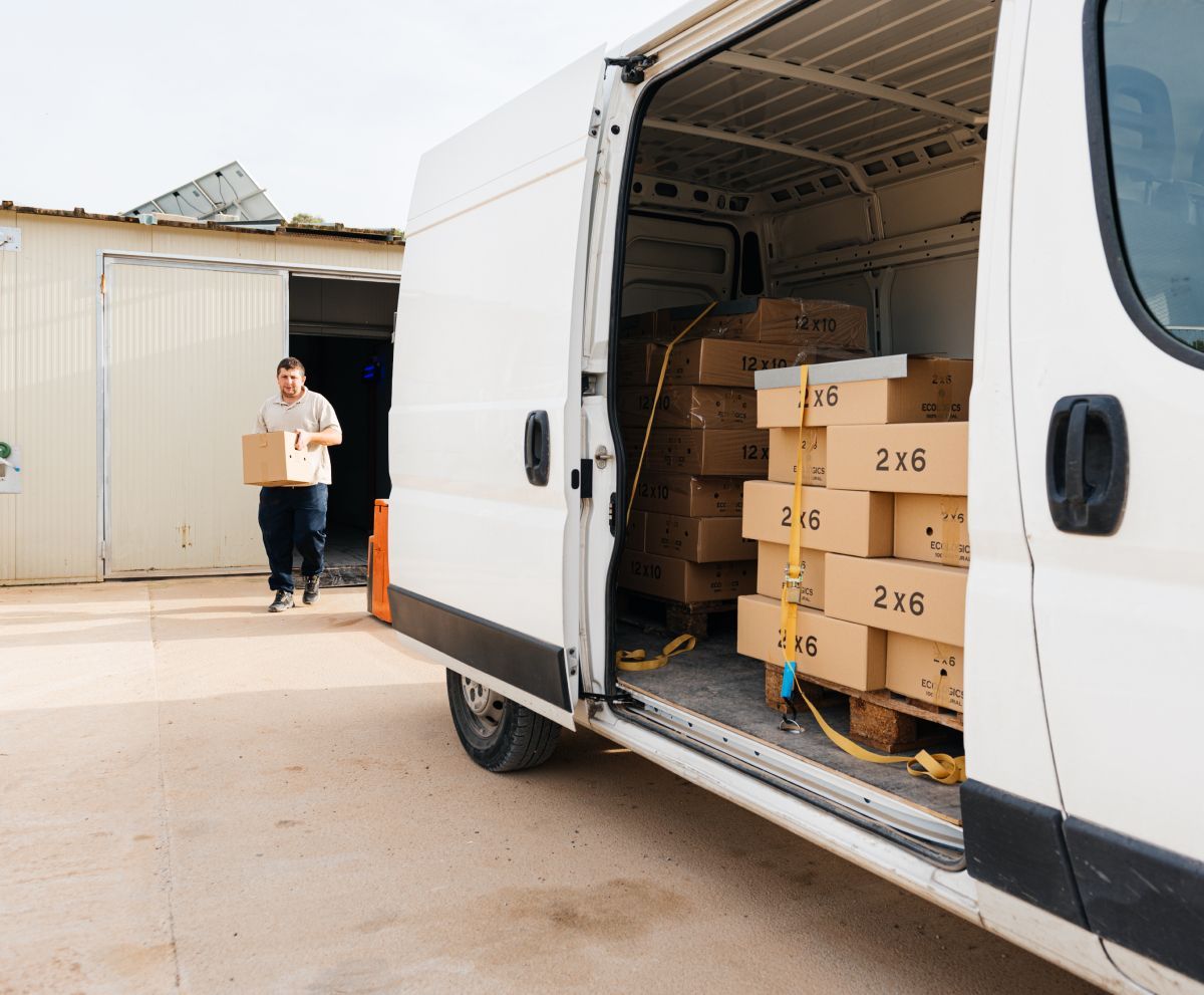 A man is loading boxes into a white van.
