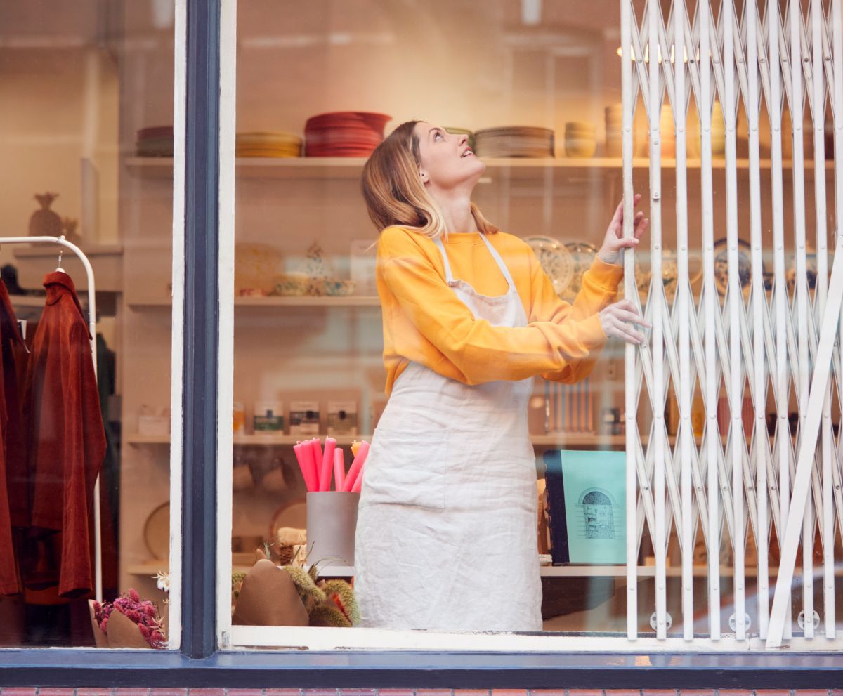 A woman is looking out of a store window.