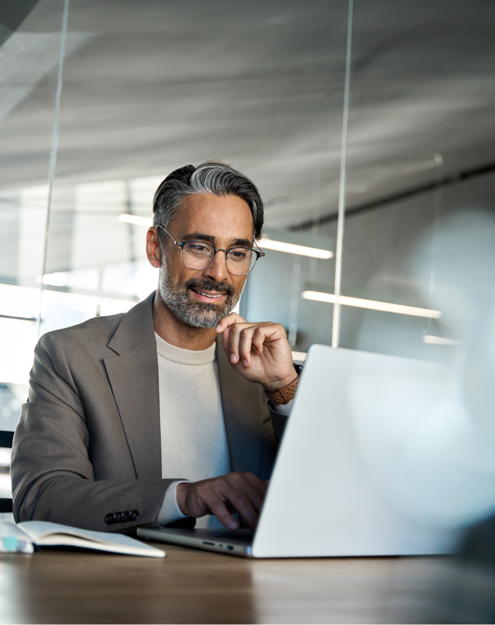 A man is sitting at a table using a laptop computer.