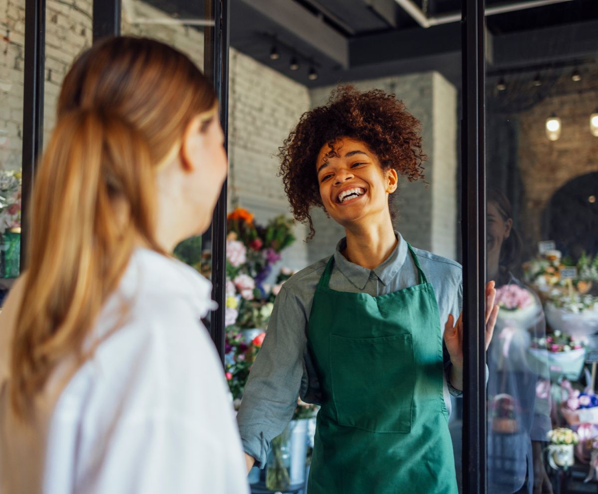A woman is looking at herself in a mirror in a flower shop.