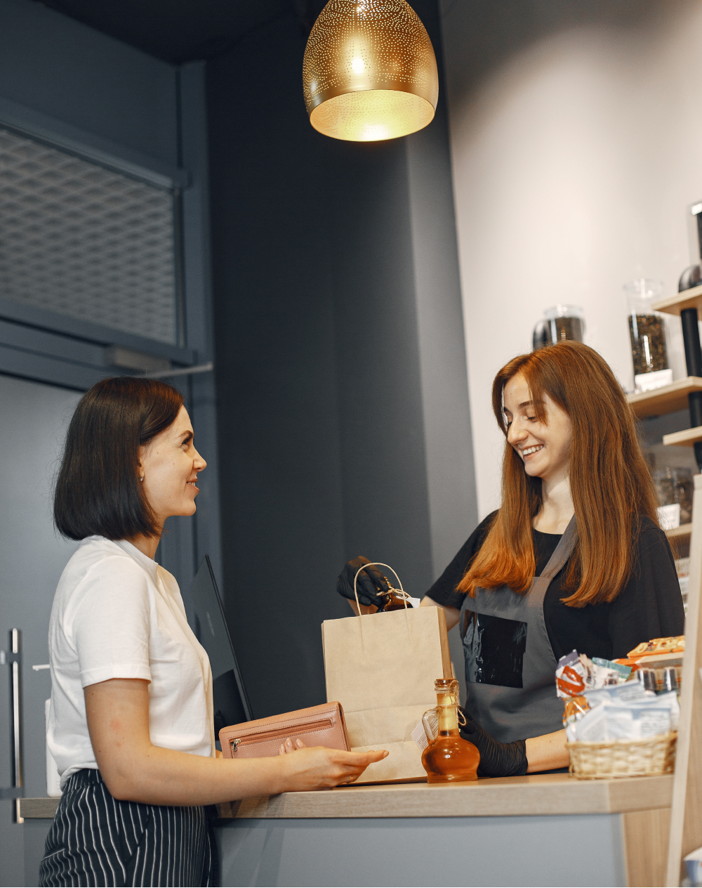 A woman is standing at a counter talking to another woman.