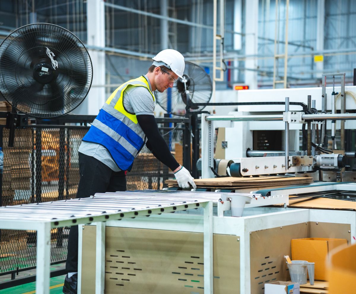 A man is working on a machine in a factory.