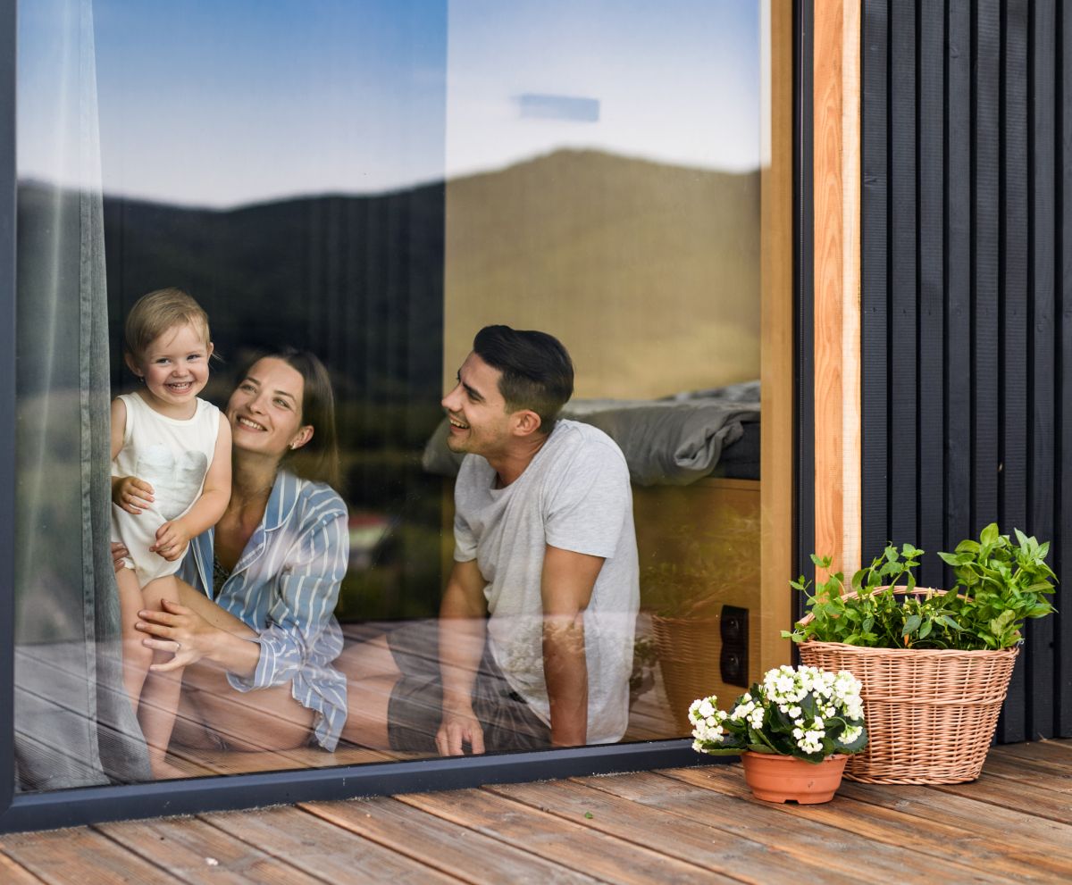 A family is looking out of a window at the mountains.