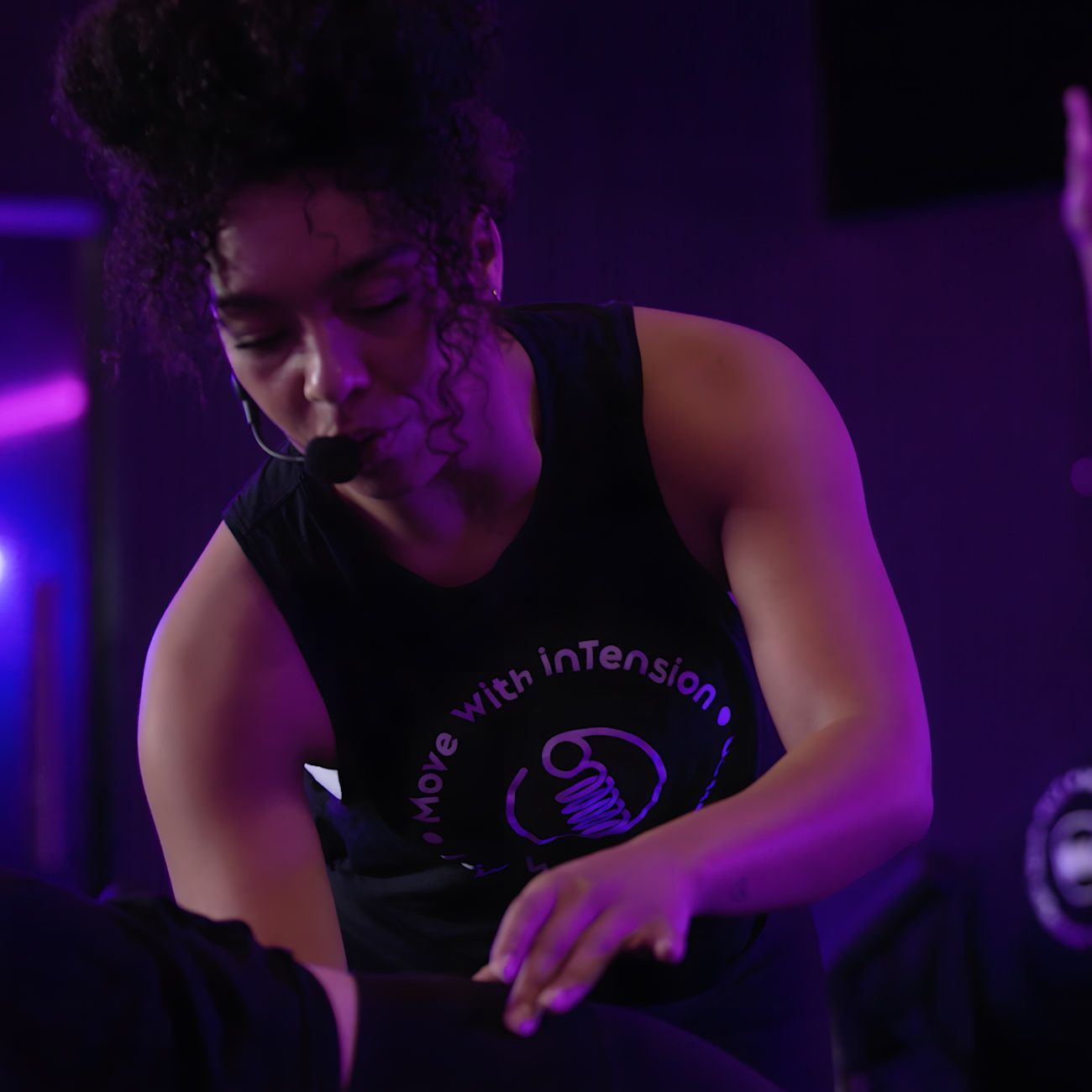 A woman wearing a black tank top that says move with intension it