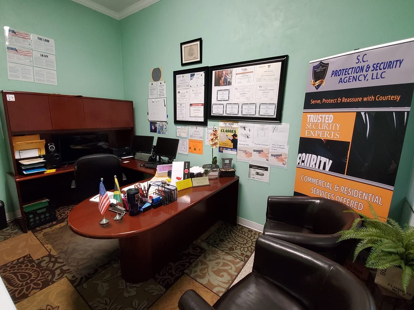 Small office with desk, chairs, bulletin boards, and mint green walls