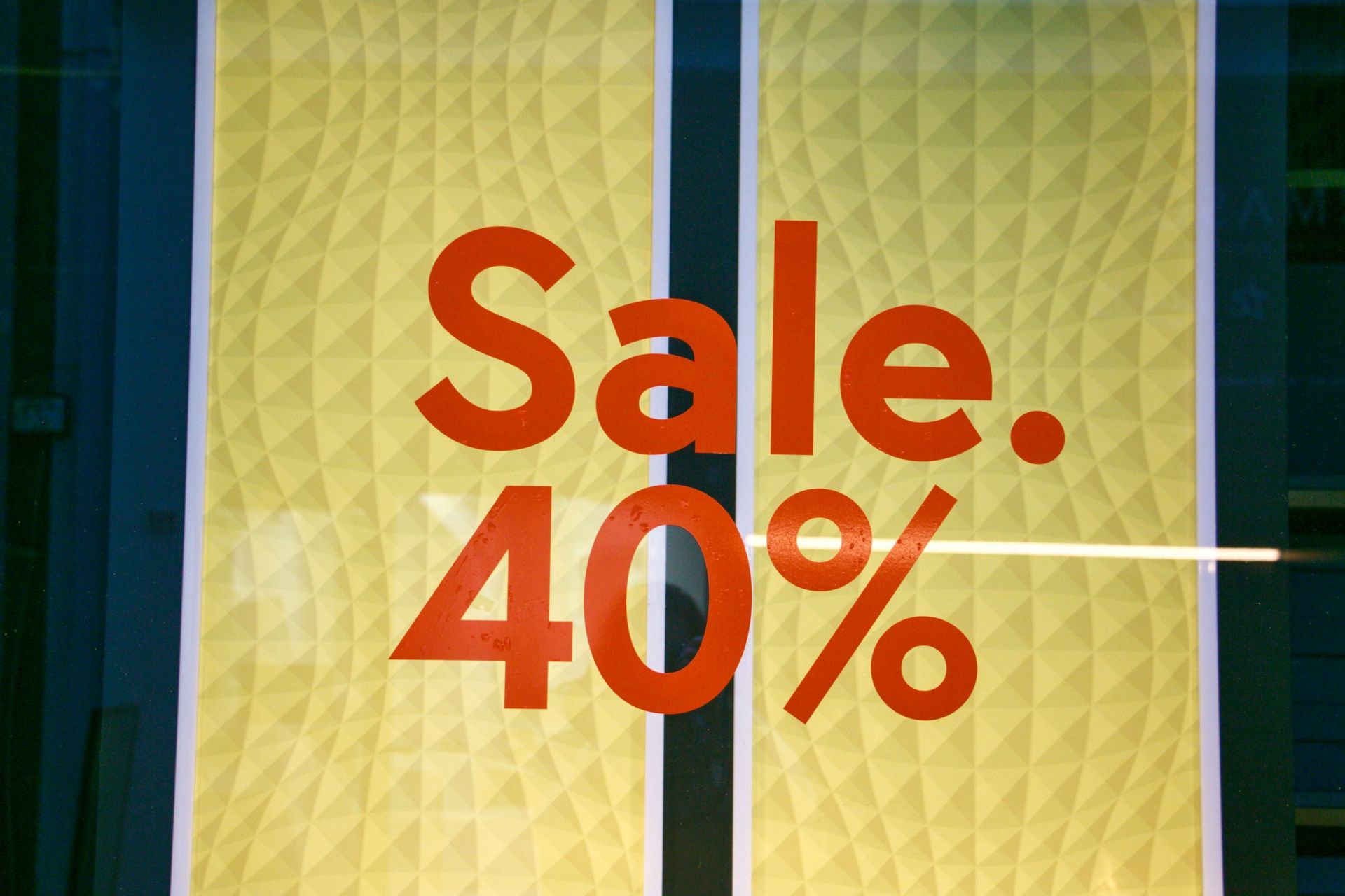 Yellow storefront sign reading “Sale 40%” in red letters
