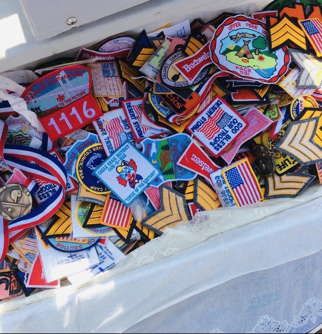 A box filled with colorful embroidered patches and badges stacked together