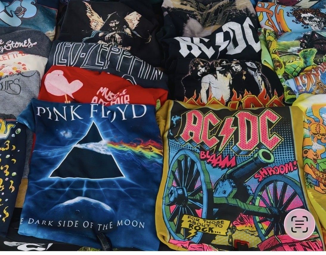 Assorted rock band graphic T-shirts, including Pink Floyd, AC/DC, and AC/DC designs, laid out in a grid.