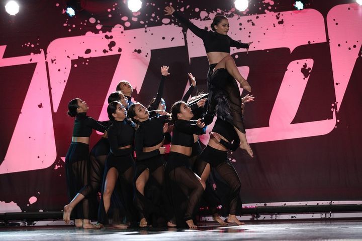 A group of women are performing a dance on a stage.