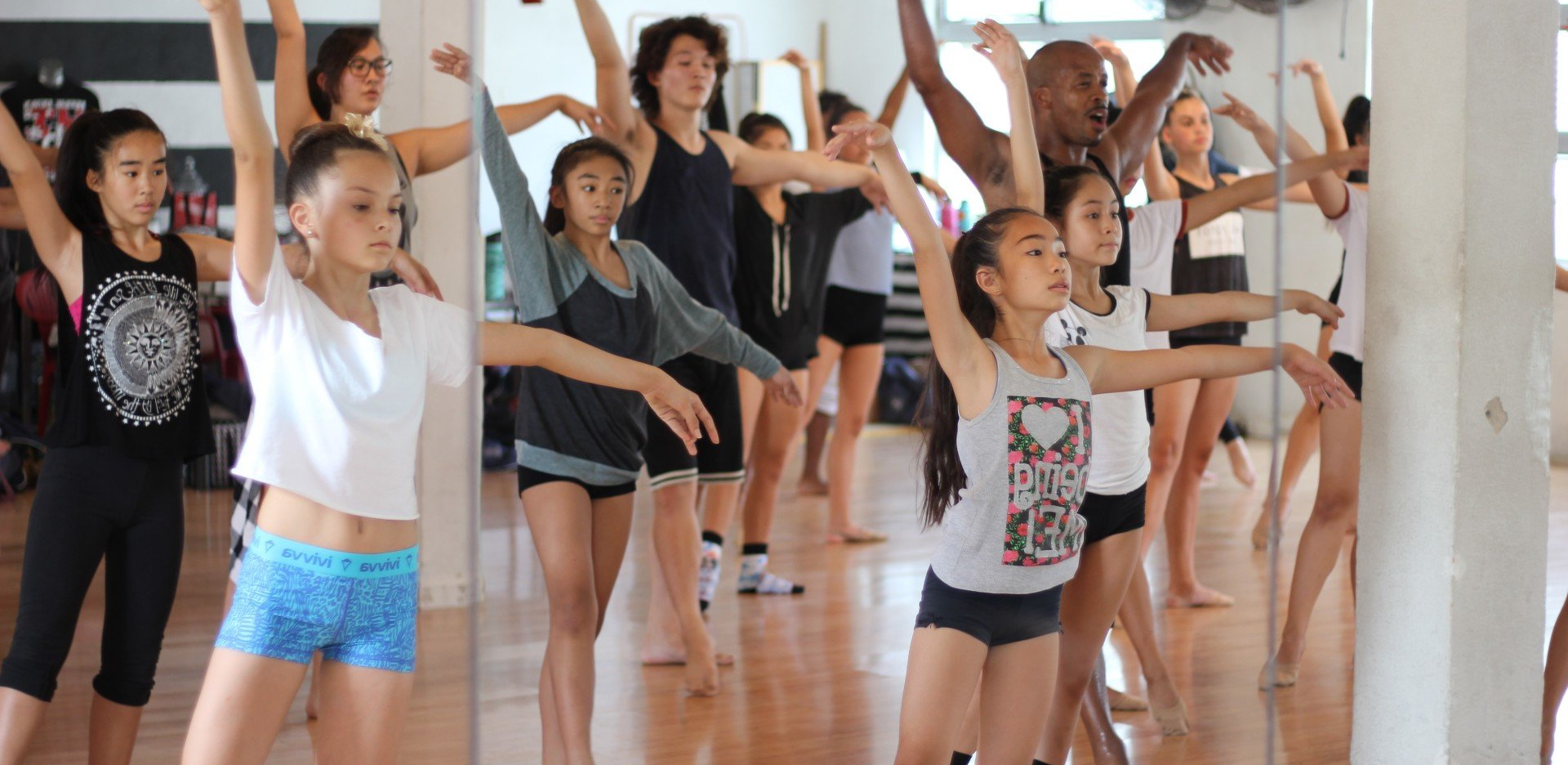 A group of young girls are dancing in a dance studio.