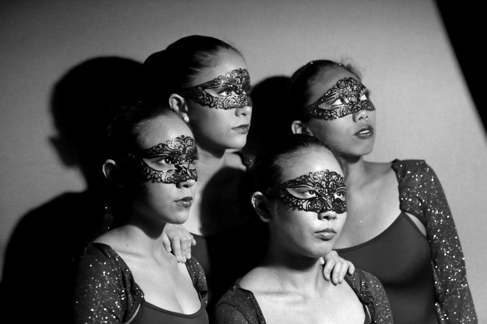 Three women wearing masks are standing next to each other