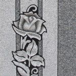 Black and white rose carving on a stone surface.