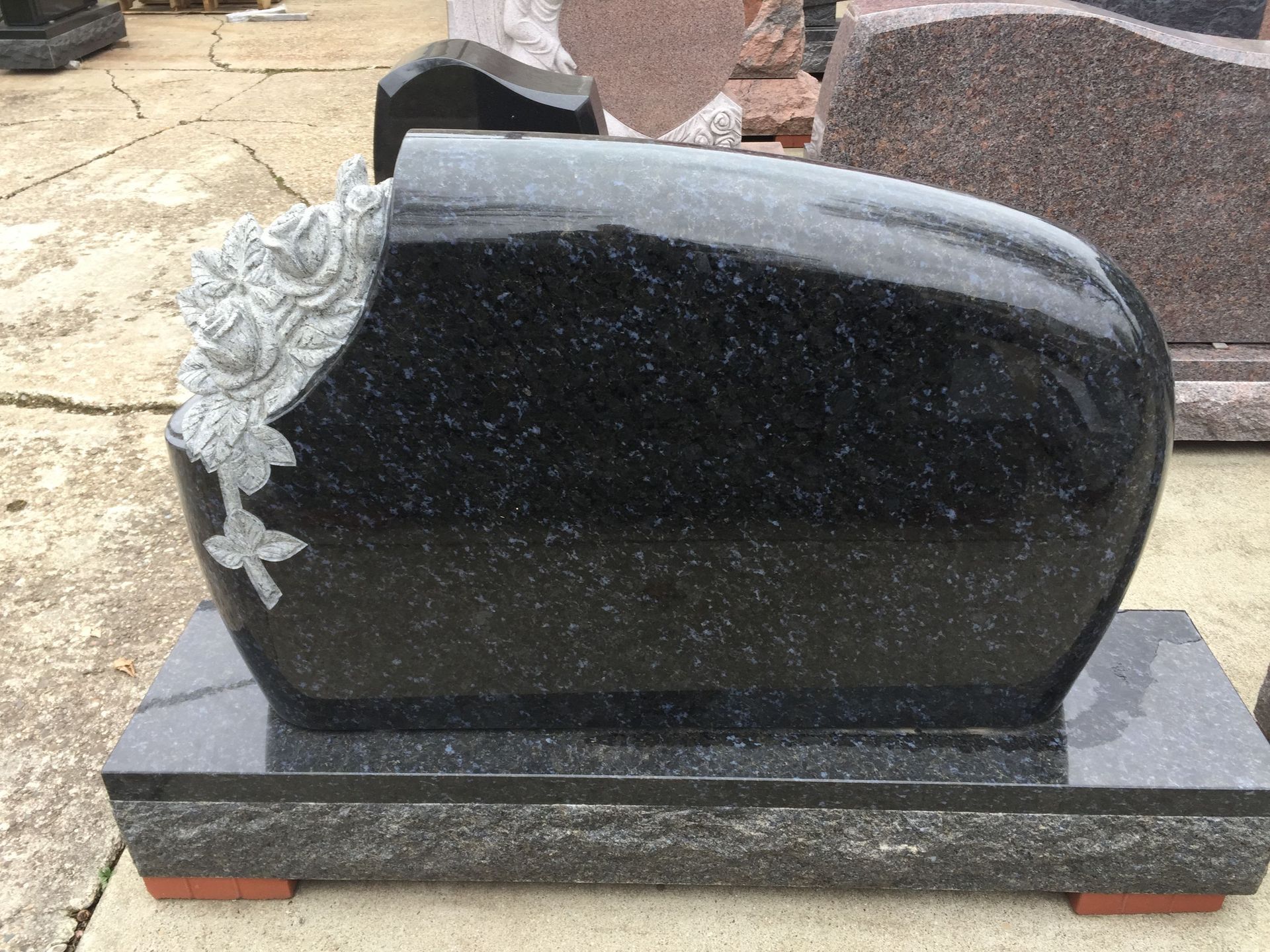 Black granite headstone with carved roses.