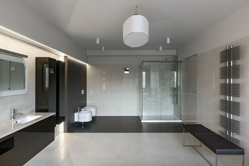 A bathroom with a walk in shower and a sink