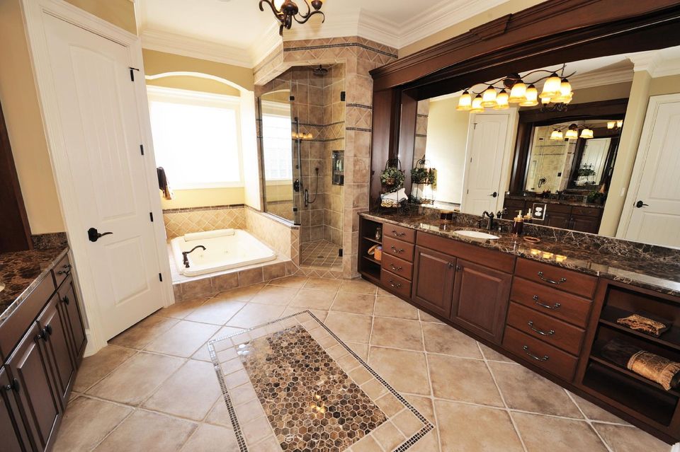 A bathroom with two sinks , a tub and a shower