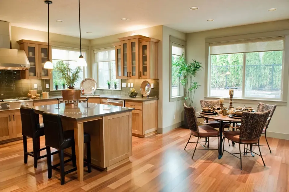 A kitchen and dining room in a house with hardwood floors.