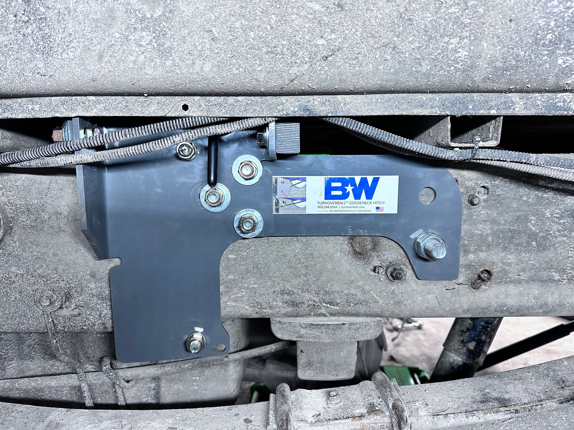 Gray metal bracket attached to a truck chassis, with