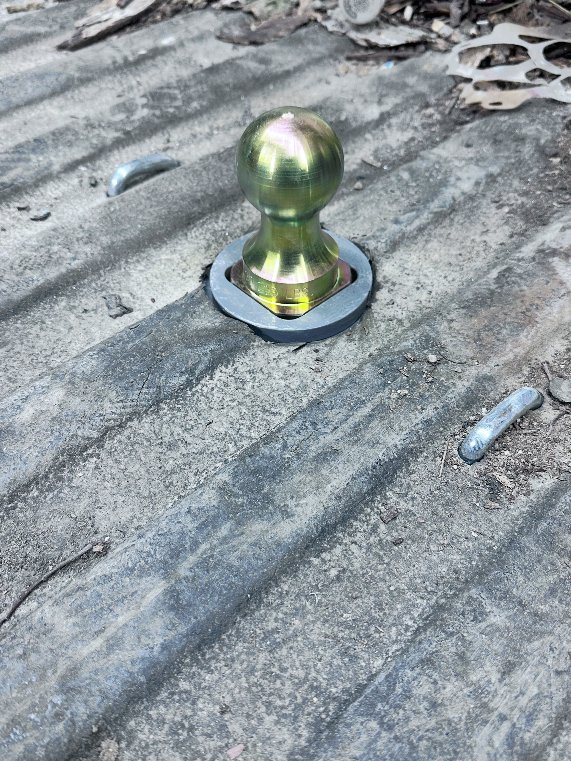 Yellow gooseneck hitch ball on a gray truck bed. | Midwest Tire & Service LLC