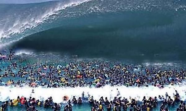 A crowd of people are swimming in the ocean near a large wave.