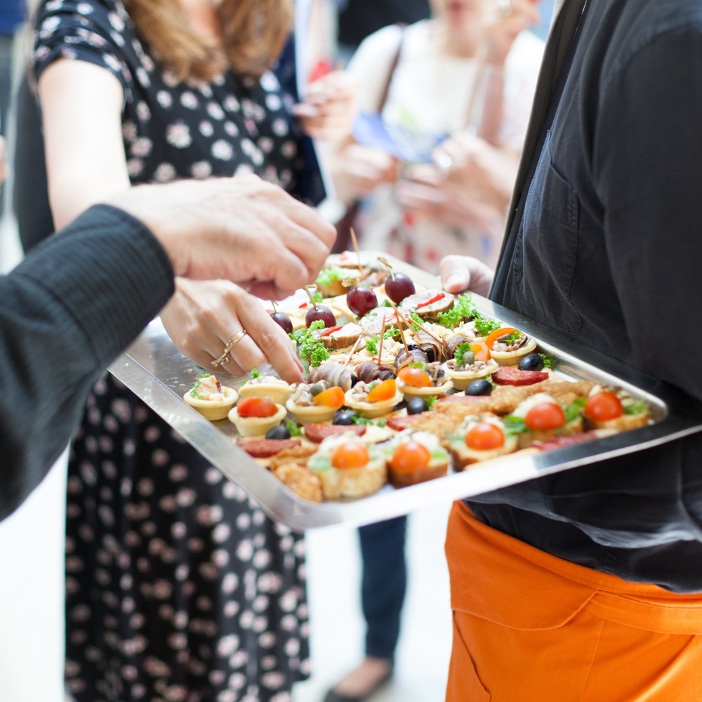 Corporate catering setup with formal table settings, glassware, and professional event service