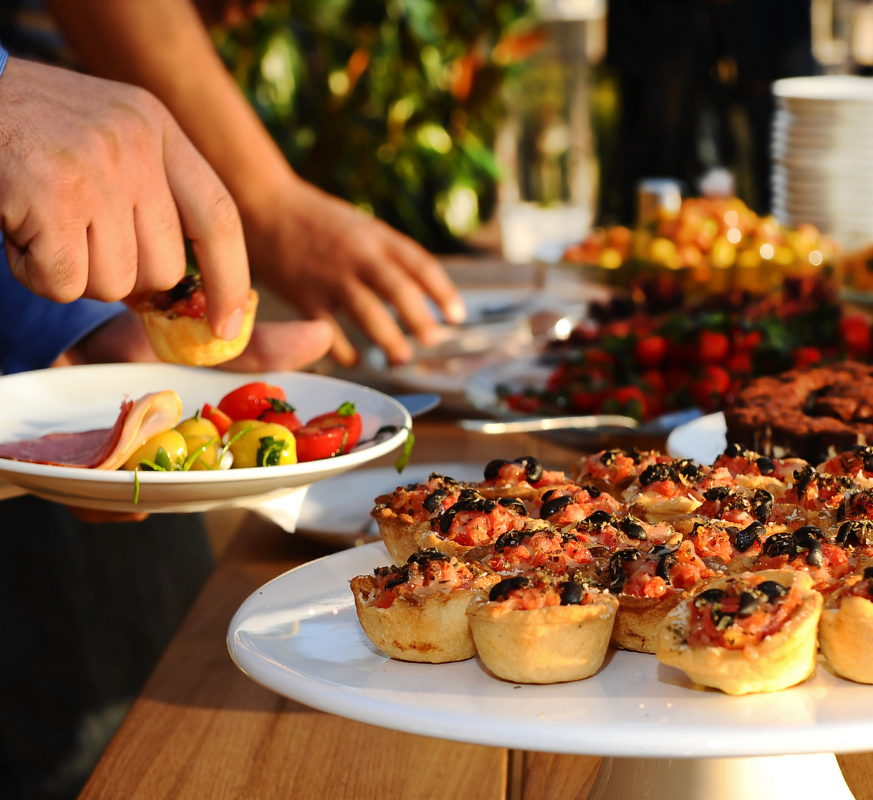 Corporate catering setup with formal table settings, glassware, and professional event service