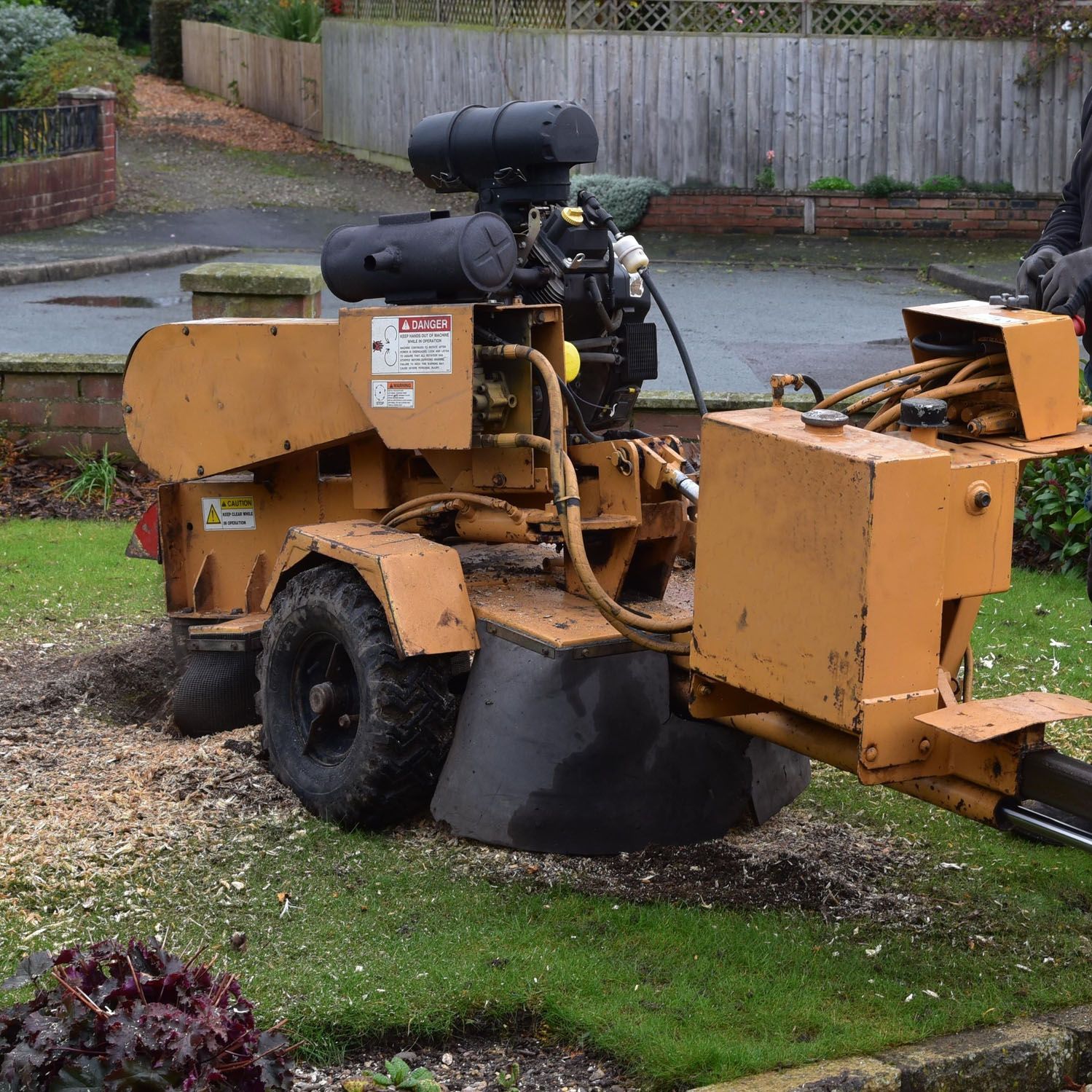 A stump grinder is parked in a lush green yard A stump grinder is parked in a lush green yard