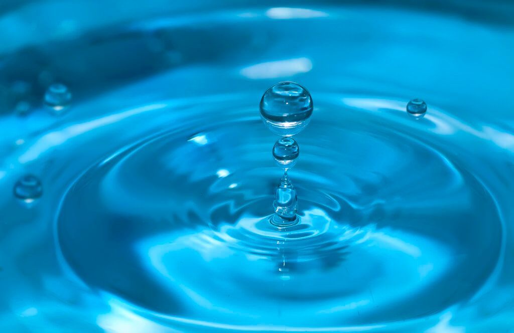 A drop of water is falling into a pool of water.