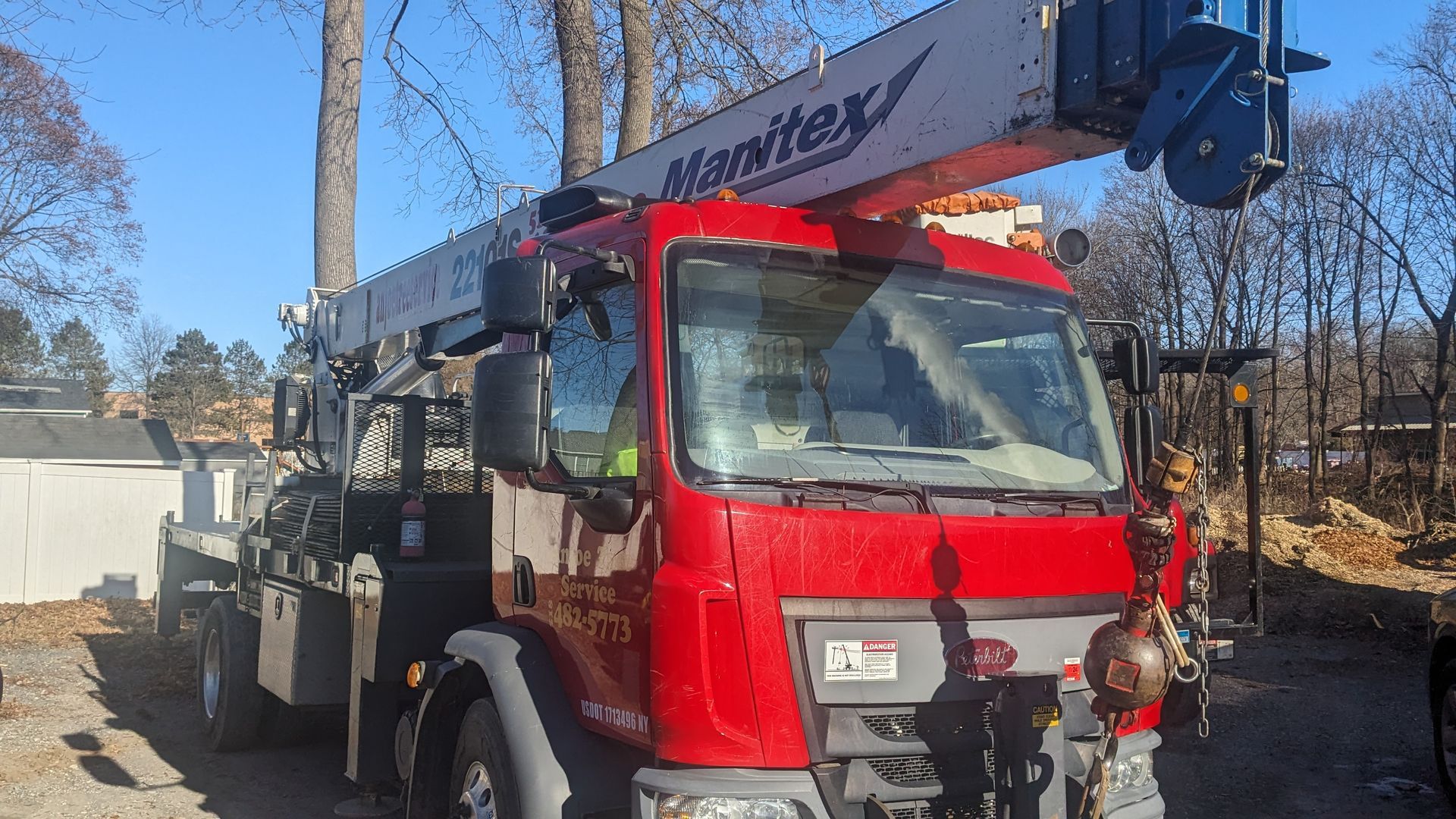 A red and white manitou truck is parked in a parking lot.